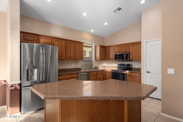 kitchen with appliances with stainless steel finishes, a center island, and light tile patterned floors