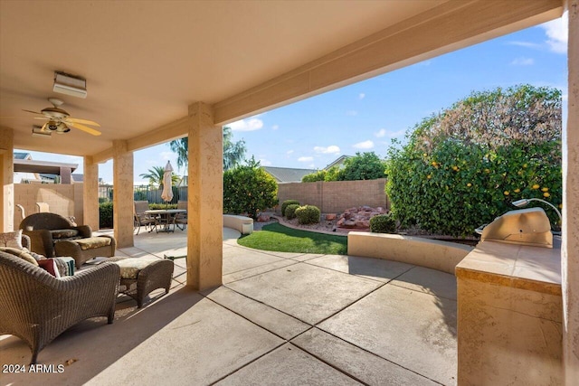 view of patio with ceiling fan and an outdoor kitchen