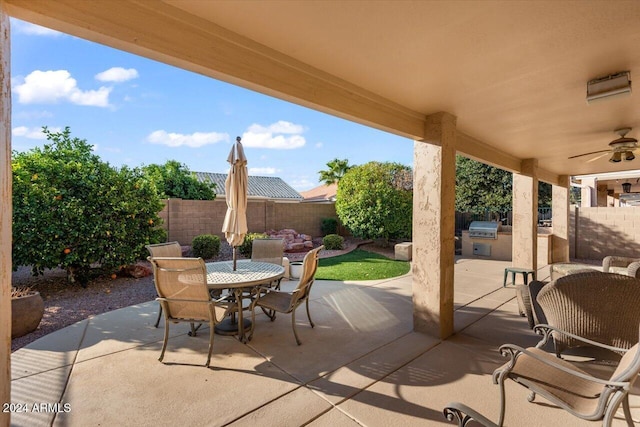 view of patio with area for grilling, ceiling fan, and an outdoor kitchen