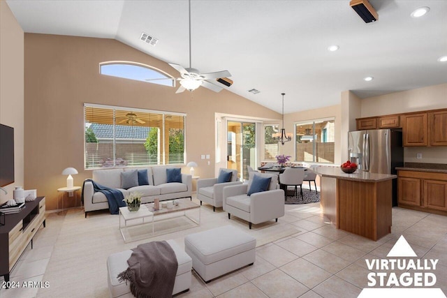 tiled living room with ceiling fan with notable chandelier and lofted ceiling