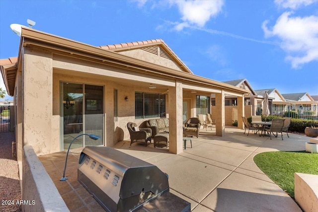 back of house with an outdoor living space, a patio, and ceiling fan