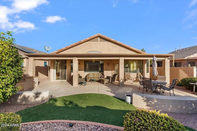 back of house featuring outdoor lounge area, an outdoor kitchen, and a patio area