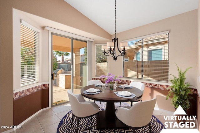 tiled dining room featuring a notable chandelier, plenty of natural light, and vaulted ceiling