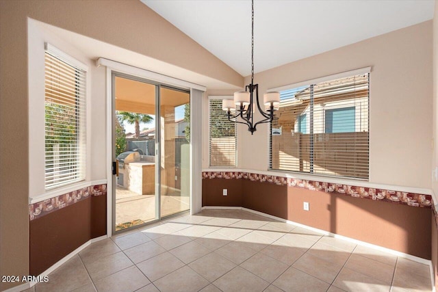 unfurnished dining area with a wealth of natural light, light tile patterned floors, lofted ceiling, and a notable chandelier