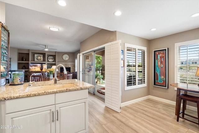 kitchen with recessed lighting, ceiling fan, light wood-style floors, and a sink