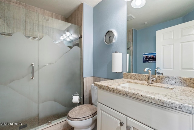 full bathroom featuring vanity, toilet, and a stall shower