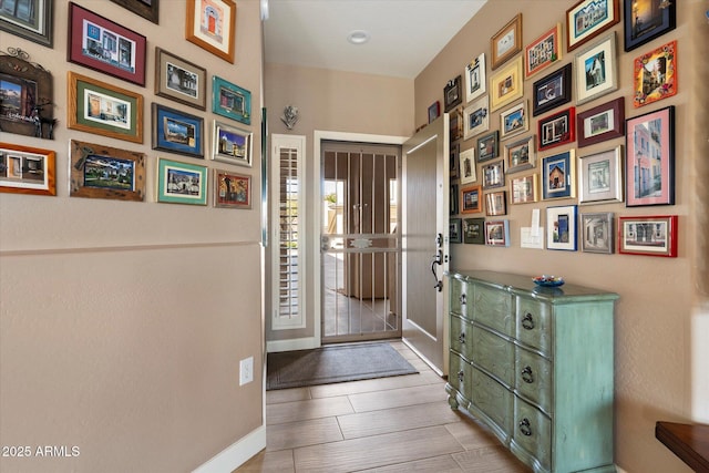 foyer featuring baseboards and wood finished floors