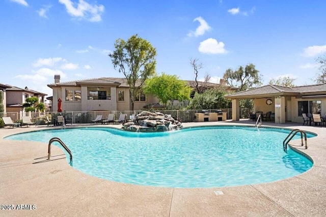 community pool with fence and a patio area