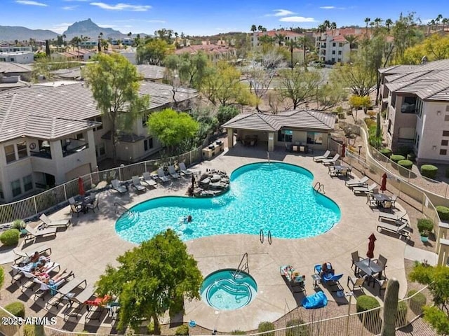 pool with a mountain view, a patio, a community hot tub, and fence