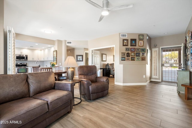 living area with visible vents, baseboards, and light wood-style flooring