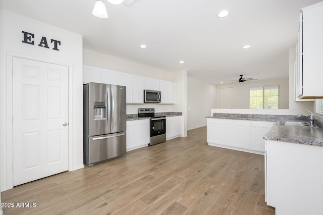 17864 W Paraiso Dr, Surprise, AZ 85387 - kitchen with stainless steel appliances, light wood finished floors, white cabinetry, and a sink
