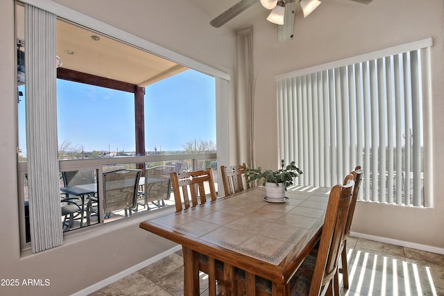 tiled dining space featuring baseboards and ceiling fan