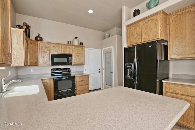 kitchen with black appliances, light countertops, a peninsula, and a sink