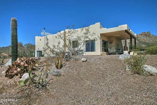 rear view of house featuring stucco siding