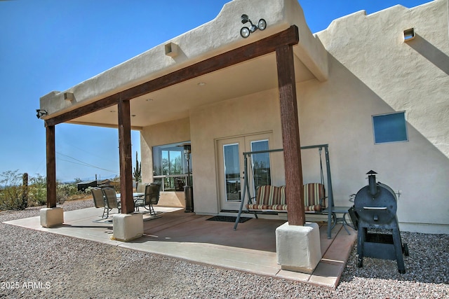 back of property featuring outdoor dining space, a patio, and stucco siding