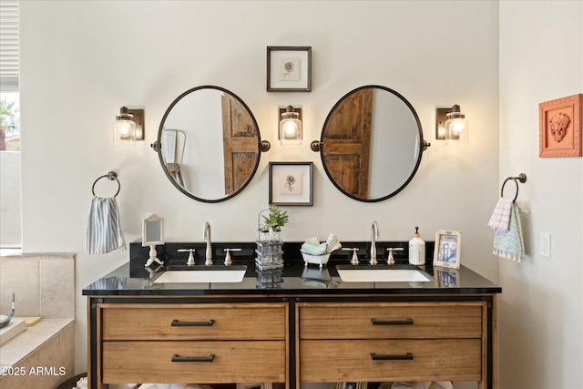 bathroom with double vanity, a tub to relax in, and a sink