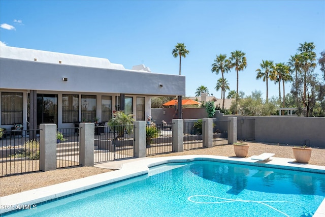 view of pool with a diving board, a patio, fence, and a fenced in pool