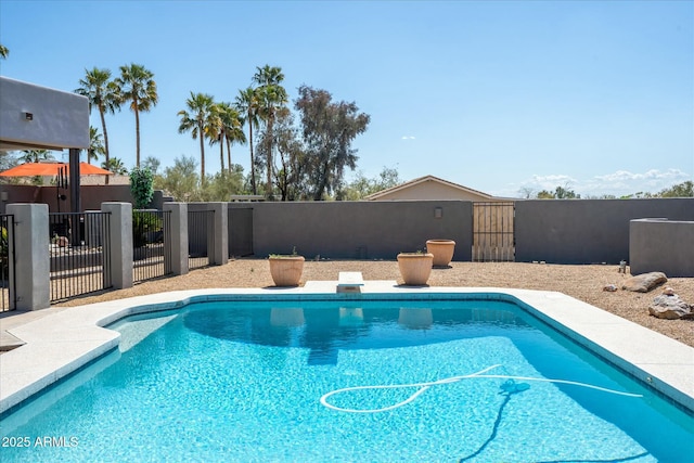 view of pool featuring a diving board, fence, and a fenced in pool