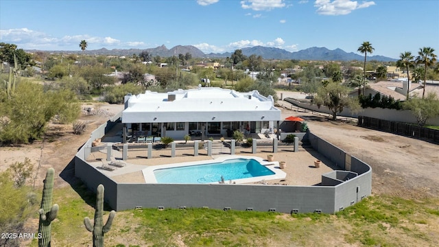 rear view of house with a patio area, a fenced backyard, a mountain view, and a fenced in pool