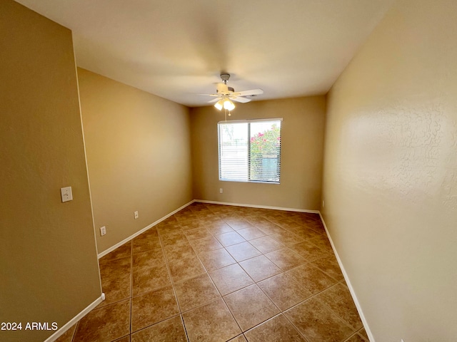 spare room featuring tile patterned flooring and ceiling fan