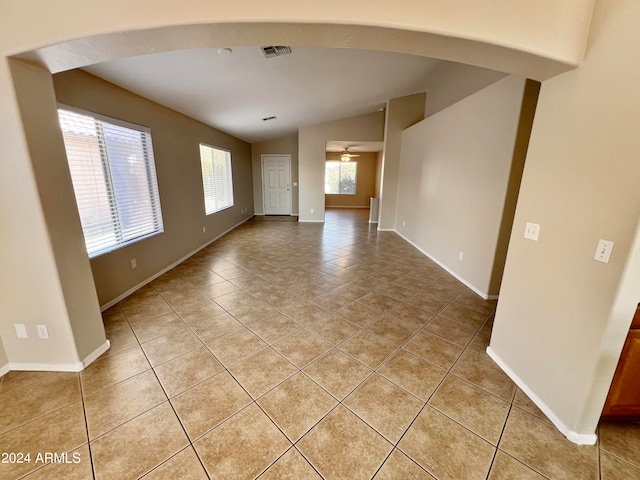 tiled empty room with ceiling fan and lofted ceiling