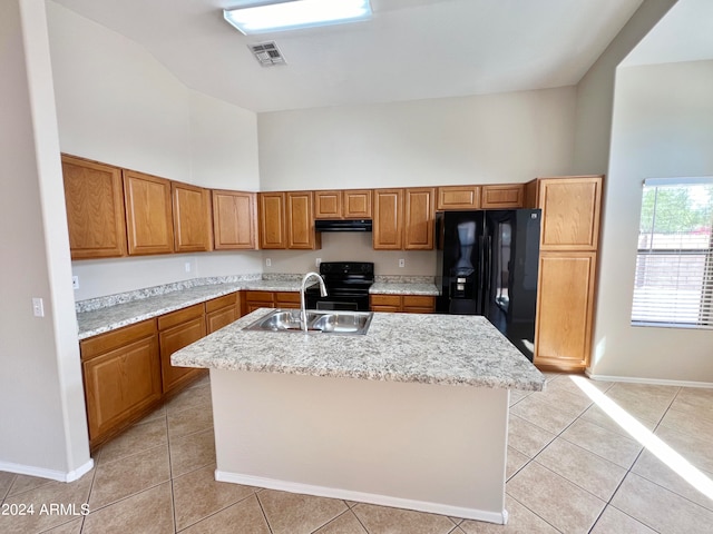 kitchen with sink, black appliances, light tile patterned floors, a center island with sink, and a high ceiling