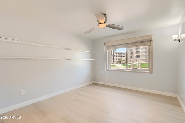 7970 E Camelback Rd Unit 110, Scottsdale, AZ 85251 - spare room with baseboards, a ceiling fan, and light wood finished floors