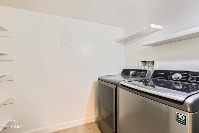 7970 E Camelback Rd Unit 110, Scottsdale, AZ 85251 - laundry area featuring washing machine and clothes dryer, laundry area, baseboards, and light wood-style floors