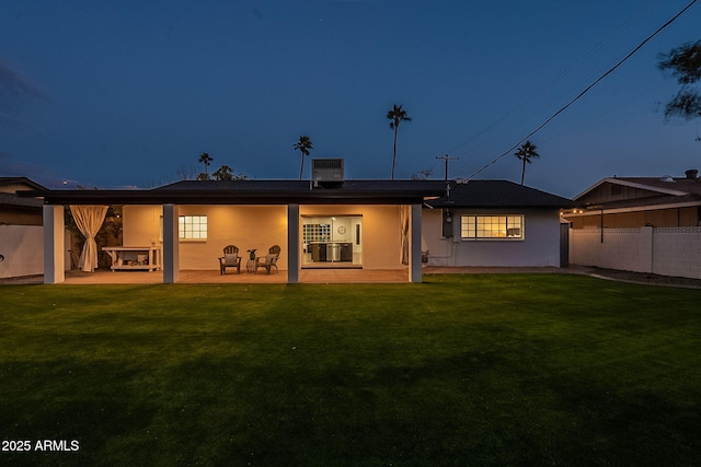 rear view of property featuring a patio area, a yard, and central AC