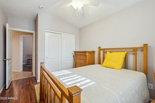 bedroom with vaulted ceiling, a closet, dark wood-type flooring, and ceiling fan