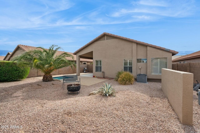 back of property with a fenced in pool and a patio area