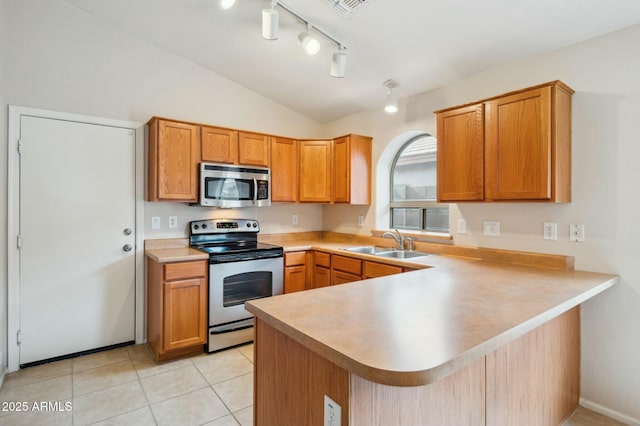 kitchen featuring sink, stainless steel appliances, kitchen peninsula, lofted ceiling, and light tile patterned floors