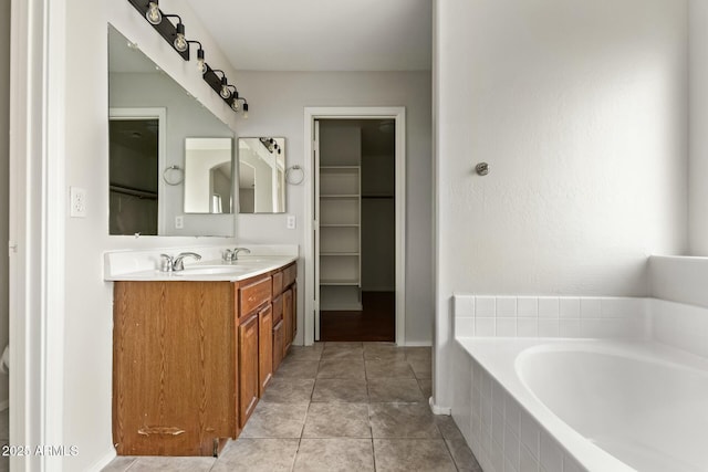 bathroom with tile patterned floors, vanity, and tiled tub