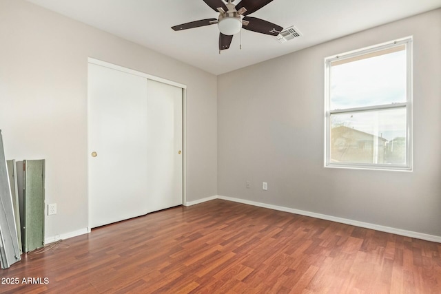 unfurnished bedroom featuring hardwood / wood-style flooring, ceiling fan, and a closet