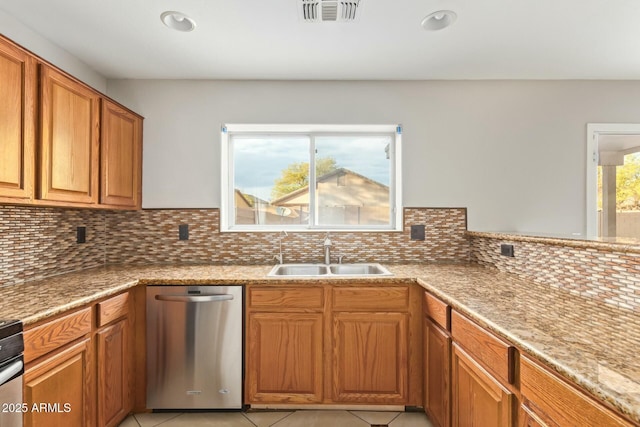 kitchen featuring tasteful backsplash, sink, light tile patterned floors, and dishwasher