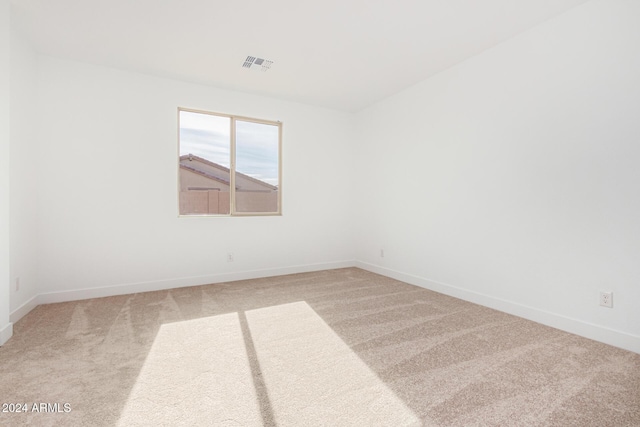 unfurnished room featuring carpet floors, baseboards, and visible vents