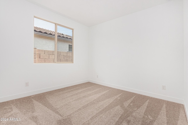 empty room with carpet and baseboards