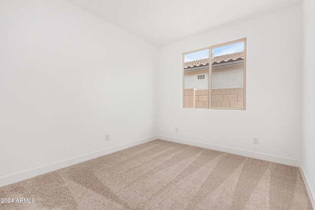 spare room with carpet and baseboards