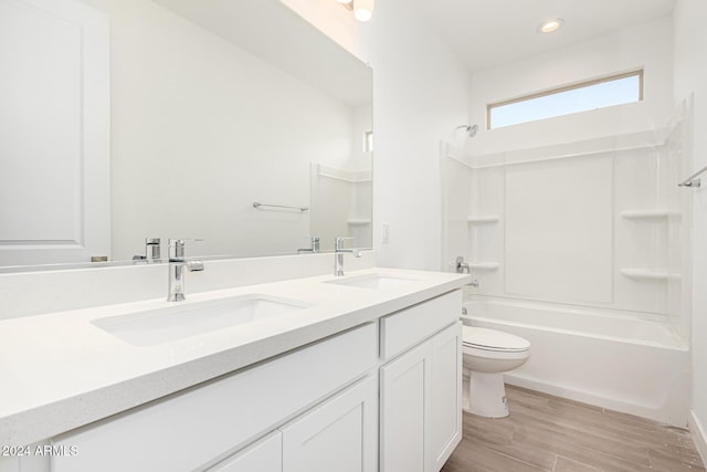 full bath with shower / bathtub combination, wood finished floors, a sink, and toilet