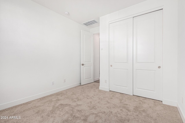 unfurnished bedroom with light colored carpet, visible vents, and baseboards