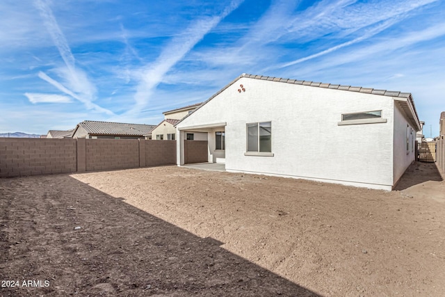 rear view of property with a fenced backyard and stucco siding