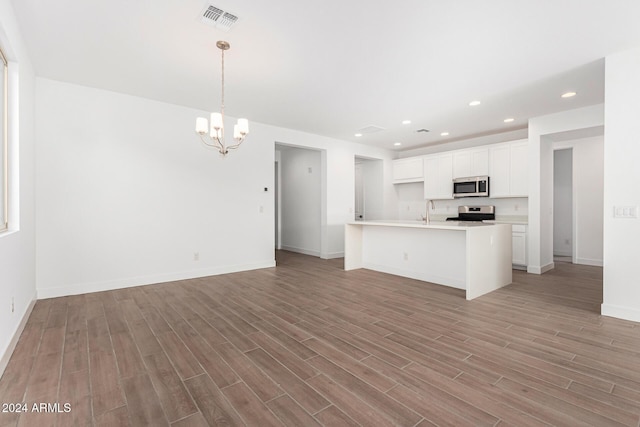 kitchen with light countertops, hanging light fixtures, appliances with stainless steel finishes, open floor plan, and white cabinets