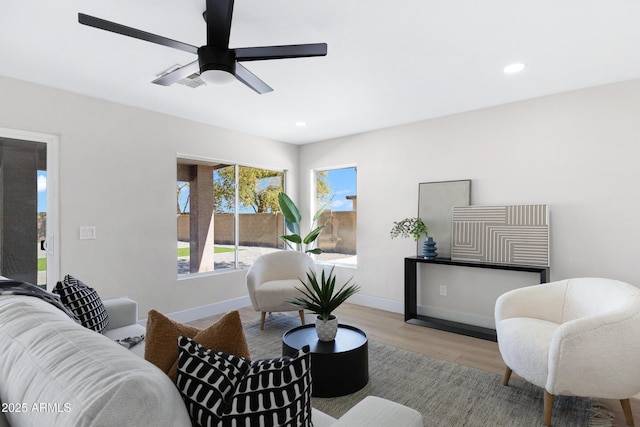 living area with baseboards, wood finished floors, and recessed lighting