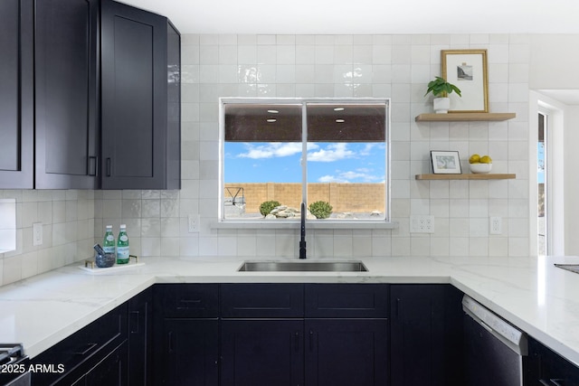 kitchen featuring dishwasher, tasteful backsplash, dark cabinets, and a sink