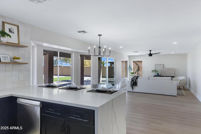 kitchen featuring visible vents, open floor plan, stainless steel dishwasher, backsplash, and open shelves