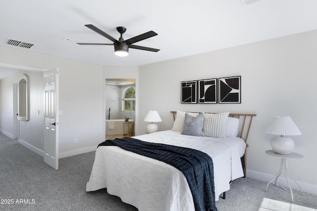 bedroom featuring ceiling fan, carpet floors, visible vents, baseboards, and ensuite bath