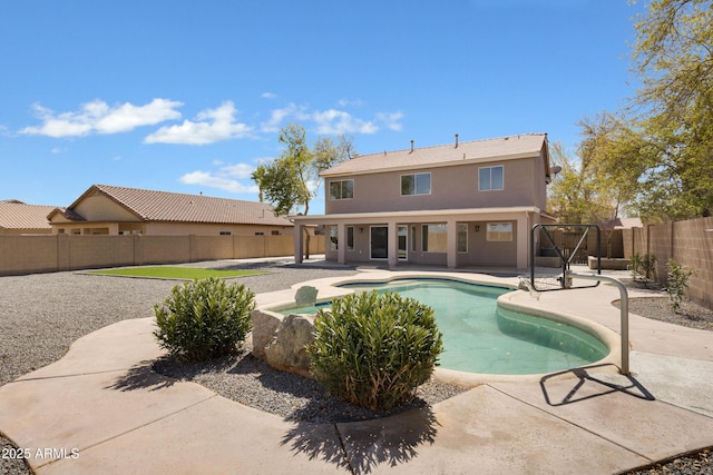 back of house with a fenced in pool, a patio area, a fenced backyard, and stucco siding