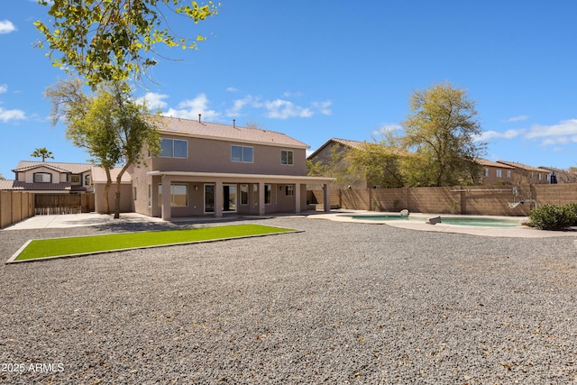 back of property with a patio area, a fenced backyard, and a fenced in pool