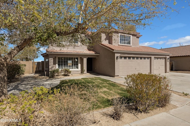 traditional home featuring a tile roof, stucco siding, concrete driveway, an attached garage, and fence