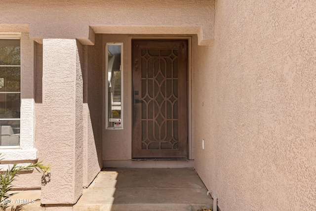 view of exterior entry with stucco siding